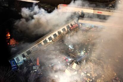 Smoke rises from trains as firefighters and rescuers operate after a collision near Larissa city, Greece, early Wednesday, March 1, 2023.