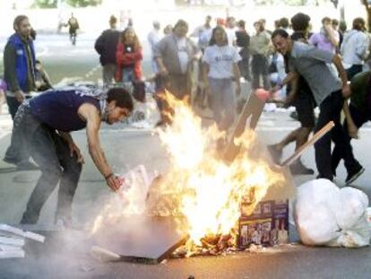 Dos jóvenes atizaban ayer una hoguera para protestar contra el ALCA en pleno centro de Buenos Aires.