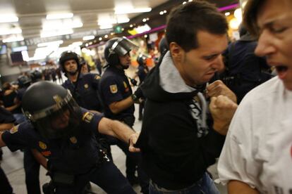 La polic&iacute;a espa&ntilde;ola antidisturbios utilizar sus porras contra los miembros de un piquete durante la huelga de trenes en la estaci&oacute;n de Atocha en Madrid.