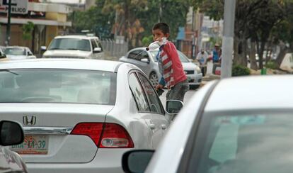 Un niño de Tuxtla Gutiérrez (Chiapas) limpia el parabrisas de un automóvil.