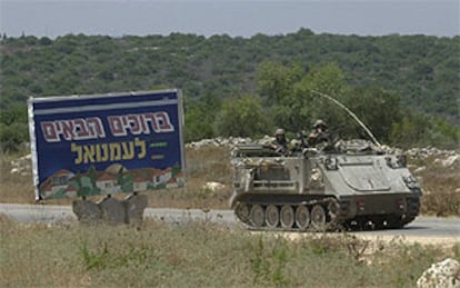 Un blindado israelí circula junto a un cartel que reza &#39;Bienvenido a Emanuel&#39;, colonia judía en Cisjordania.