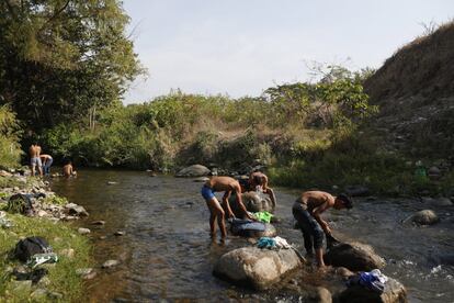 Migrantes param em um riacho na cidade de Mapastepec, no Estado mexicano de Chiapas, no domingo, 21 de abril. Caravana segue em direção aos EUA, apesar da ofensiva das autoridades mexicanas que deteve centenas no início da semana. 