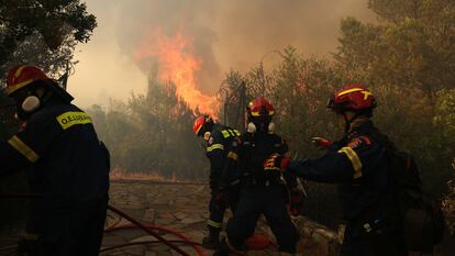 Un grupo de bomberos trata de extinguir un incendio en la región de Stamata.