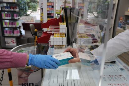 Un farmacéutico vende una caja de Paracetamol en su farmacia.