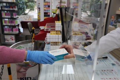 Un farmacéutico vende una caja de Paracetamol en su farmacia.