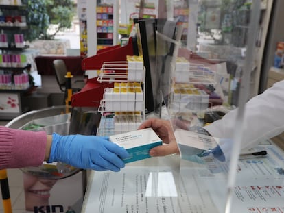 Un farmacéutico vende una caja de Paracetamol en su farmacia.