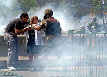 Dos manifestantes forcejean con un guardia nacional durante los disturbios del pasado viernes en Caracas.