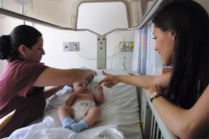 Una mujer de origen dominicano, a la izquierda, viste a su hijo en el Elmhurst Hospital de Nueva York, en una imagen de archivo.