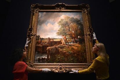 Two Christie&rsquo;s employees hold up John Constable&rsquo;s The Lock, which was sold on Tuesday.  