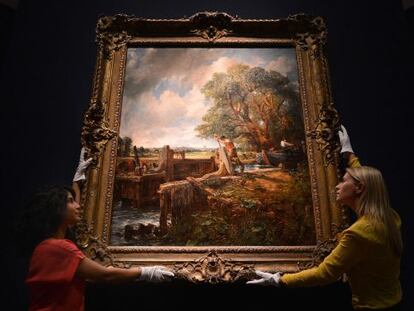 Two Christie&rsquo;s employees hold up John Constable&rsquo;s The Lock, which was sold on Tuesday.  