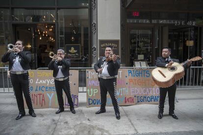 A mariachi band sings outside the office of a lawyer who abused Spanish speakers at a restaurant.