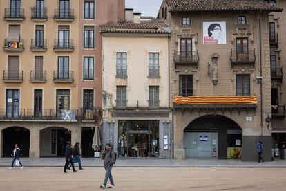 La plaza mayor de Vic (Barcelona) con una gran senyera en un balcón, banderas esteladas (independentistas) y una pancarta con la imagen de Carles Puigdemont.