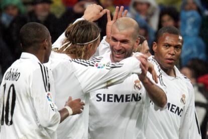 Guti abraza a Zidane tras uno de sus goles ante Robinho y Baptista.