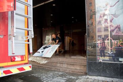 Un hombre achica agua del Teatre Victoria en el Paralelo barcelonés.