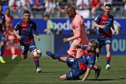 Kevin-Prince Boateng, en el suelo, golpea la pelota ante la presión de Jorge Pulido del Huesca.