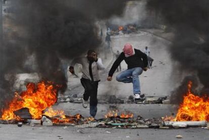 Dos palestinos, durante los disturbios que se registraron ayer en el este de Jerusalén.