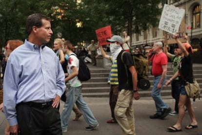 Un hombre de negocios observa a alguno de los manifestantes que forman parte del movimiento Occupy Wall Street.