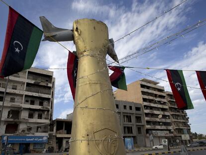 Símbolos gadafistas con edificios destrozados al fondo, en la avenida de Trípoli en Misrata.