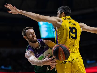 El escolta del Unicaja Tyler Kalinoski da una asistencia ante el pívot del Lenovo Tenerife Gio Shermadini.