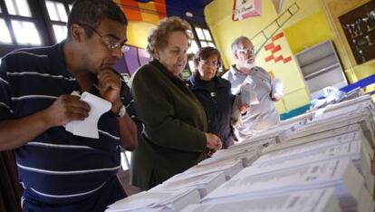 Varios ciudadanos eligen las papeletas para votar, en el colegio Pi i Margall de Madrid, durante la jornada de votaciones de las elecciones europeas de 2009