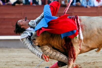 El matador Julio Aparicio en el momento en el que el pitón del toro con el que lidiaba sale por su boca.