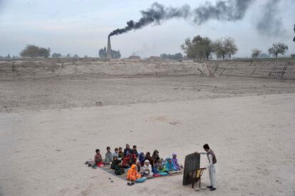 Escolares afganos atienden una clase al aire libre en un campamento de refugiados a las afueras de Jalalabad (Afganist&aacute;n). 