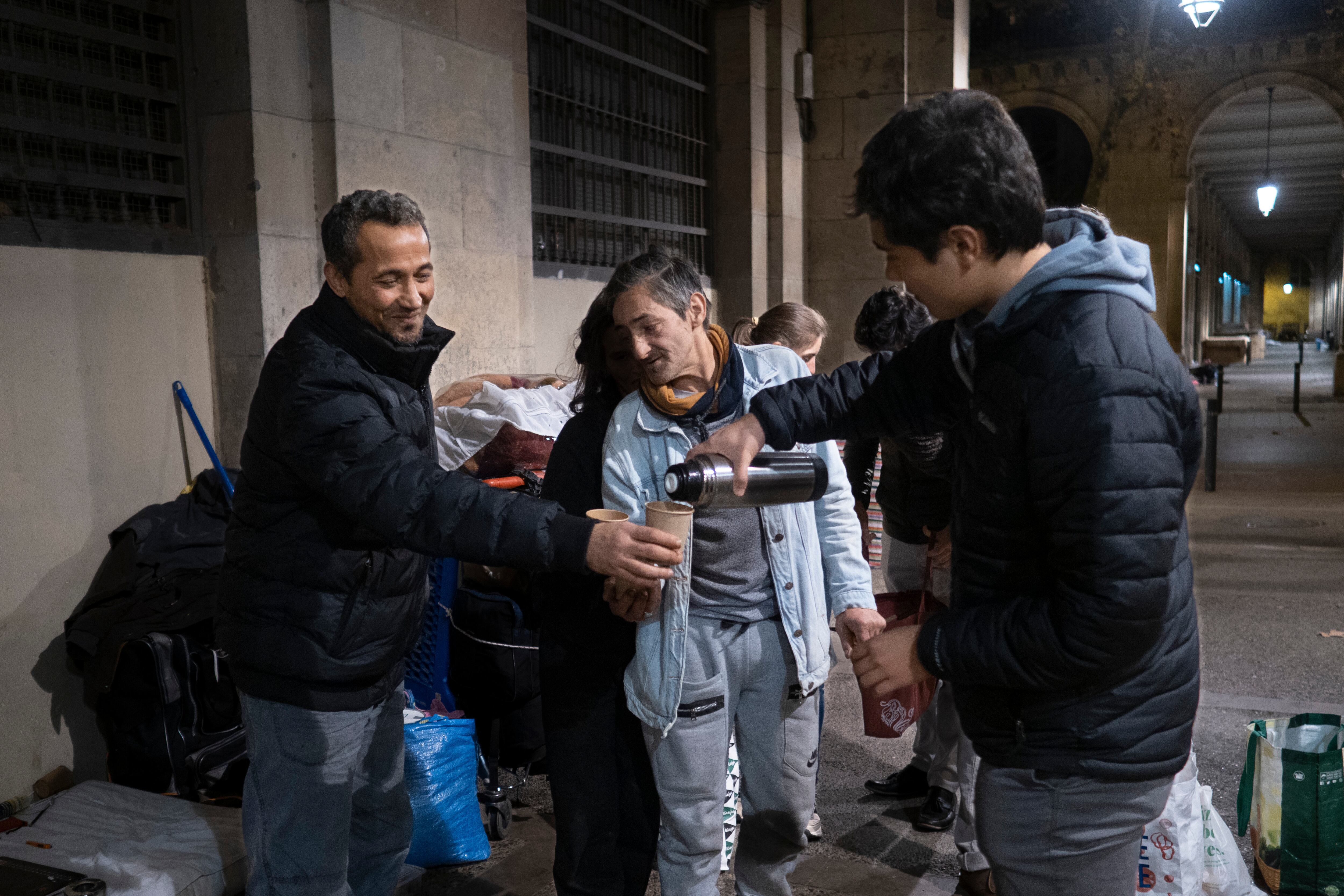 Hasán y El Portu reciben café de unos voluntarios.