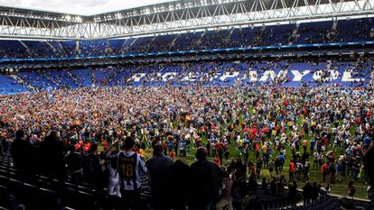 La afición del Espanyol festeja sobre el césped de Cornellà.