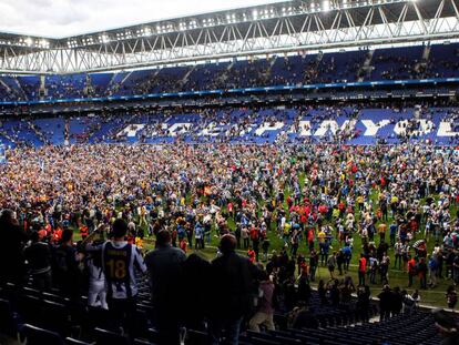 La afición del Espanyol festeja sobre el césped de Cornellà.