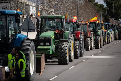 Varios tractores parados en la carretera esperan en Arganda del Rey, con motivo de las protestas convocadas este sábado en Madrid. 