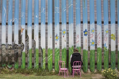 Una mujer espera reencontrarse a través del muro con su marido en Tijuana.