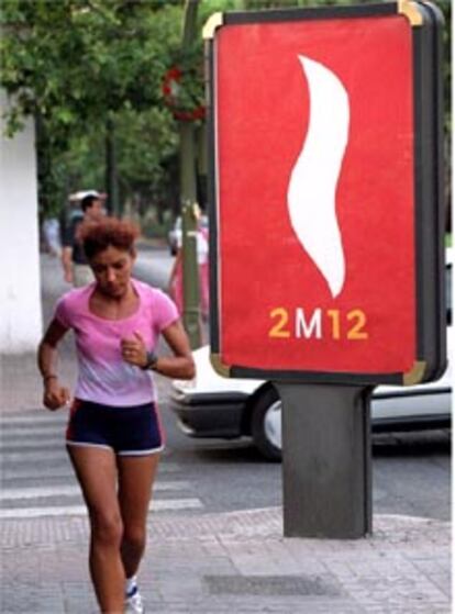 Una joven pasa haciendo footing junto al logotipo olímpico Madrid 2012, en una imagen de archivo