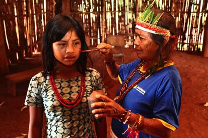 Dona Tereza, rezadeira da Reserva Bororó, pinta a neta para um ritual. Desmatamento na região dificulta a localização das ervas medicinais, extraídas da mata nativa, usadas pelos índios para a confecção dos remédios tradicionais.