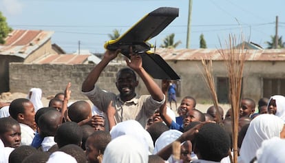 Escolares del distrito de Tandale en Dar es Salaam (Tanzania), observan una pequeña aeronave no pilotada o dron.
