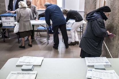 Un grupo de gente vota en un centro electoral en Lyon.