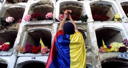 Un hombre pone flores a las víctimas de un atentado terrorista en Bogotá.