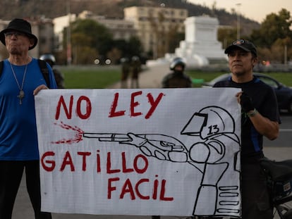 Dos hombres portan una pancarta contra los cambios legislativos promovidos por el Gobierno de Gabriel Boric, el pasado 31 de marzo, en Santiago (Chile).