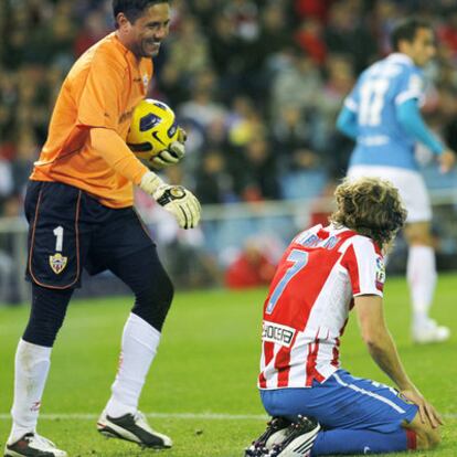 Alves sonríe a Forlán con el balón bien sujeto tras un ataque fallido del Atlético.