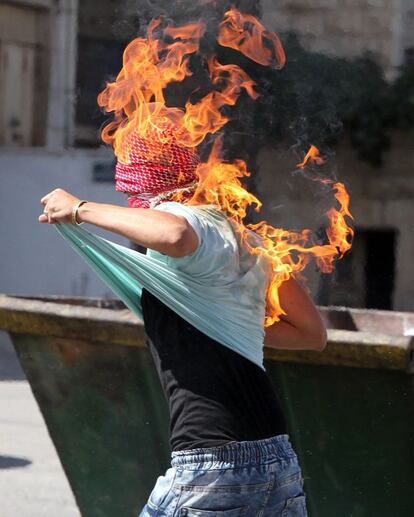 Un palestino se prende fuego al lanzar un cóctail molotov contra soldados israelíes durante una protesta en Hebrón (Palestina).