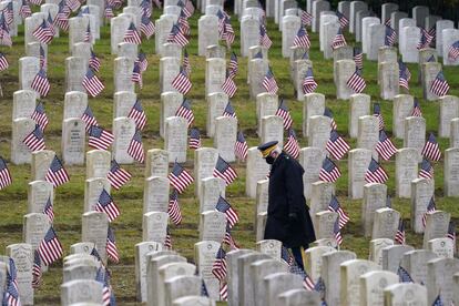 Un miembro retirado del ejército de los Estados Unidos camina entre las tumbas cubiertas con banderas, en el cementerio de Evergreen Washelli el Día de los Veteranos, en Seattle. El Día de los Veteranos es un festivo federal en Estados Unidos y se celebra cada 11 de noviembre, fecha del armisticio que puso fin a la Primera Guerra Mundial en 1918.