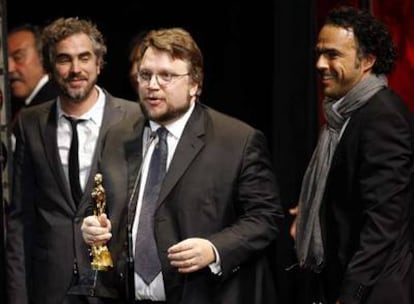 El cineasta mexicano Guillermo del Toro acompañado por sus colegas Alfonso Quaron (i) y Alejandro Gonzalez Iñarritu (d) recibe el Ariel a la mejor película.