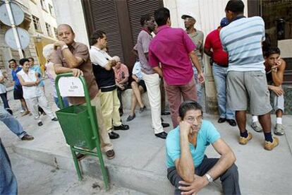 Un grupo de cubanos aguarda la apertura de una casa de cambio para comprar <i>pesos convertibles.</i>