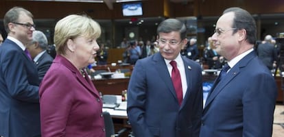 La canciller alemana, Angela Merkel, charla con el primer ministro turco, Ahmet Davutoglu, y el presidente franc&eacute;s, Francois Hollande, en la cumbre extraordinaria sobre la inmigraci&oacute;n.