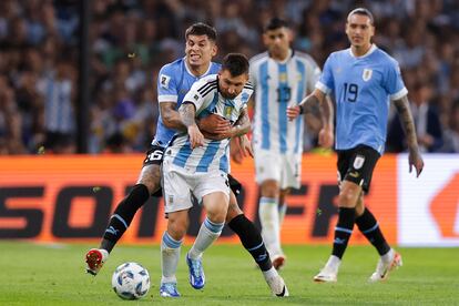 Lionel Messi disputa el balón con Mathías Olivera, en el duelo entre Argentina y Uruguay en el estadio La Bombonera en Buenos Aires.