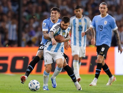 Lionel Messi disputa el balón con Mathías Olivera, en el duelo entre Argentina y Uruguay en el estadio La Bombonera en Buenos Aires.