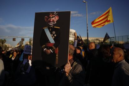 Un manifestant sosté una caricatura de Felip VI durant les protestes d'aquest dilluns als voltants del Palau de Congressos.