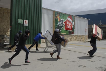 Un grupo de asaltantes sale a la carrera con mercanca robada de un supermercado en San Carlos de Bariloche.