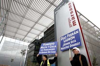 Dos trabajadores de Viajes Marsans protestan por el retraso en cobrar sus nóminas ante la sede del grupo propiedad de Gerardo Díaz Ferrán y Gonzalo Pascual.