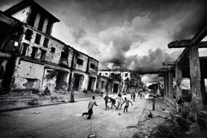 Un grupo de niños juega en las calles de Mogadiscio entre edificios arrasados por la guerra.