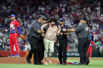 A fan is removed from the field after running on during the World Baseball Classic Semifinals between Team Cuba and Team USA